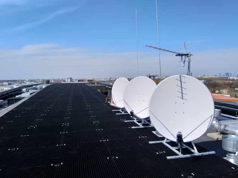 Installation d’antennes satellites sur le toit d’un hôtel — panorama de la ville en arrière-plan