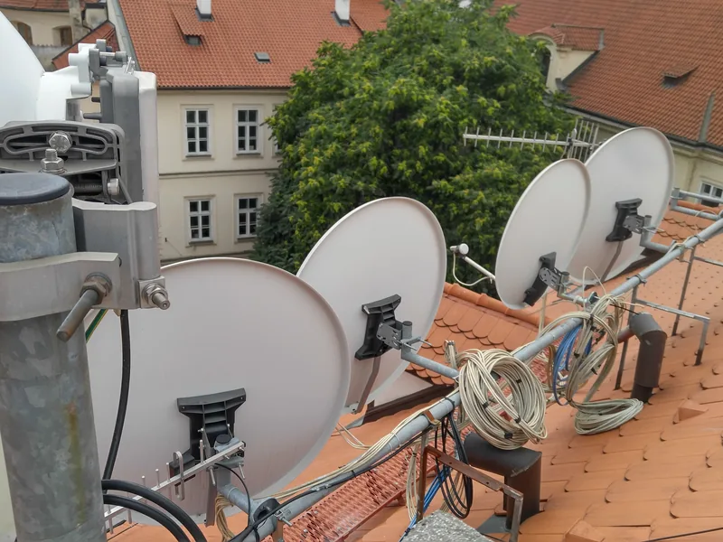 Montage d’une tête de réseau — antennes satellites sur un toit dans un quartier historique