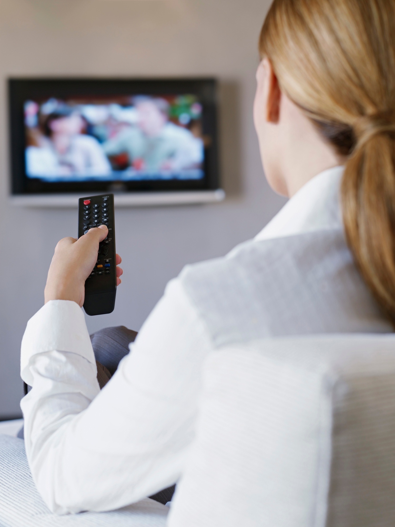 Young woman watching television in hotel room