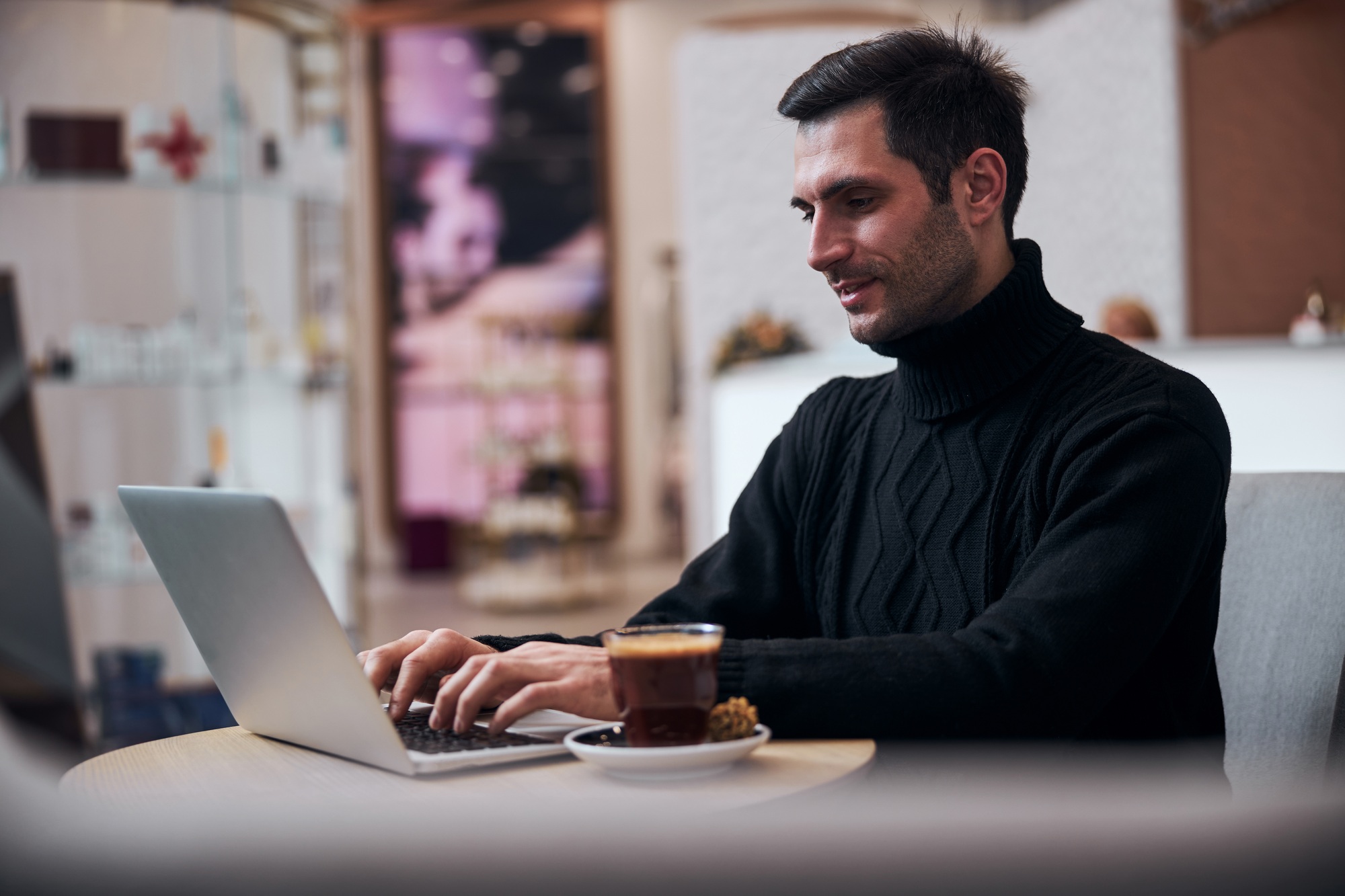 Smiling freelancer working in internet in hotel lobby